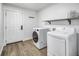 Laundry room with modern washer and dryer, white door, and wood-look flooring at 2572 Bates Se St, Smyrna, GA 30080