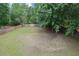Spacious, partially shaded backyard with a well-maintained lawn and a wood privacy fence at 2988 Belfaire Lake Dr, Dacula, GA 30019