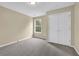 This bedroom features neutral paint, carpet, a window, and a double door closet at 2988 Belfaire Lake Dr, Dacula, GA 30019