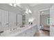 Large bathroom with double vanity, white cabinets, and a large mirror reflecting the bedroom at 3519 Preserve Se Dr, Atlanta, GA 30339