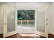 View through open french doors to a wooden deck with a railing overlooking the lush backyard at 51 Ivy Chase Ne, Atlanta, GA 30342