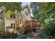Exterior view of a home with a deck and stairs leading down to a stone bench and lush backyard landscaping at 51 Ivy Chase Ne, Atlanta, GA 30342