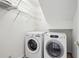 Bright laundry room featuring modern appliances and overhead storage shelving at 51 Ivy Chase Ne, Atlanta, GA 30342