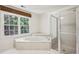 Bright bathroom featuring a large soaking tub with jets and a separate glass-enclosed shower at 51 Ivy Chase Ne, Atlanta, GA 30342