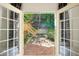 View from inside to the patio featuring a brick surface, seating, and a lush backyard at 51 Ivy Chase Ne, Atlanta, GA 30342