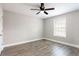 This bedroom features hardwood floors, neutral paint, a ceiling fan, and a window for natural light at 7 Villa Se Ct, Smyrna, GA 30080