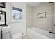Clean bathroom featuring a soaking tub, tiled walls, and modern fixtures for a relaxing experience at 7994 Devonshire Dr, Jonesboro, GA 30238