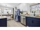 Bright kitchen featuring stainless steel appliances, blue cabinets, and stylish refrigerator at 7994 Devonshire Dr, Jonesboro, GA 30238