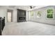 Bright bonus room with plush carpet, fireplace, media center, and multiple windows offering natural light at 110 Northwood Creek Way, Oxford, GA 30054