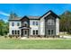 Beautiful two story home featuring stone and white siding under a clear blue sky at 110 Northwood Creek Way, Oxford, GA 30054