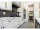 Modern kitchen with stainless steel appliances, custom cabinets, quartz countertops, and pantry access at 110 Northwood Creek Way, Oxford, GA 30054