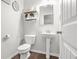 Cozy powder room featuring pedestal sink, toilet, and modern decor at 200 Cherokee Reserve Cir, Canton, GA 30115