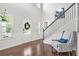 Bright foyer featuring hardwood floors, a staircase with iron railings, and a chair with accent pillow at 200 Cherokee Reserve Cir, Canton, GA 30115