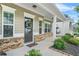 Charming covered front porch with brick accents, a wreath on the front door, and inviting curb appeal at 200 Cherokee Reserve Cir, Canton, GA 30115