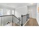 Upstairs hallway with views of the foyer below offers modern railings and hardwood floors at 200 Cherokee Reserve Cir, Canton, GA 30115