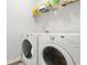 Bright laundry room with white washer, dryer, and storage shelves for organized convenience at 200 Cherokee Reserve Cir, Canton, GA 30115