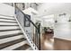 Elegant staircase with dark wood banister leading to an open dining room at 200 Cherokee Reserve Cir, Canton, GA 30115