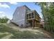 Back exterior showing the large back deck, screened-in porch, walk-out basement and large grassy yard at 421 Retreat Ln, Canton, GA 30114