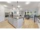 Open-concept kitchen featuring a large island with seating, stainless steel appliances, and modern lighting at 421 Retreat Ln, Canton, GA 30114