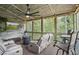 Comfortable screened-in porch with rustic decor, TV, ceiling fan, and a view of the wooded backyard at 421 Retreat Ln, Canton, GA 30114