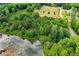 Scenic aerial view of the property showing the pond and wooded area adjacent to a paved road at 1050 Denton Rd, Douglasville, GA 30134