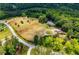 Aerial view of a large property with a house, a circular driveway, and extensive greenery surrounded by dense forest at 1050 Denton Rd, Douglasville, GA 30134
