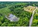 Aerial view of the property featuring mature trees, a lush landscape, and a winding road at 1050 Denton Rd, Douglasville, GA 30134