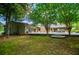 Spacious backyard featuring a large patio, stone fireplace, and lush green lawn at 1050 Denton Rd, Douglasville, GA 30134