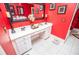 Vanity with makeup station including multiple drawers and countertop space in the bright, red bathroom at 1050 Denton Rd, Douglasville, GA 30134
