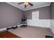Neutral toned bedroom with half wood paneled walls, ceiling fan, plush carpet, and large window at 1050 Denton Rd, Douglasville, GA 30134