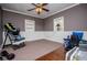 Neutral toned bedroom with half wood paneled walls, ceiling fan, plush carpet, and large window at 1050 Denton Rd, Douglasville, GA 30134