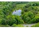 Scenic aerial view of the property showing the pond with natural surrounding wooded area at 1050 Denton Rd, Douglasville, GA 30134