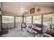 Relaxing screened-in porch features wicker seating, ceiling fan, and lovely outdoor views at 1050 Denton Rd, Douglasville, GA 30134