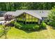 Rear exterior showcases a house with large windows, landscaped shrubs, and a well-kept lawn at 1050 Denton Rd, Douglasville, GA 30134