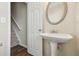 Charming powder room featuring pedestal sink, oval mirror, and new flooring at 2159 Meadow Peak Rd, Duluth, GA 30097