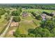 Wide aerial shot showcases a luxurious home with a vast, tree-lined property and neighboring houses at 3480 Indian Shoals Rd, Dacula, GA 30019
