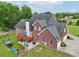 Expansive brick home features a large deck, a well-manicured lawn, and a three-car garage at 3480 Indian Shoals Rd, Dacula, GA 30019