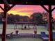 View of the landscaped backyard at sunset, featuring a pergola and outdoor seating at 3480 Indian Shoals Rd, Dacula, GA 30019