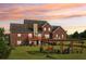 Sunset view of a beautiful backyard with a pergola, deck, and lush green lawn at 3480 Indian Shoals Rd, Dacula, GA 30019