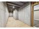 Unfinished basement with concrete walls and floors, exposed ceiling, and a doorway to a finished area at 3480 Indian Shoals Rd, Dacula, GA 30019