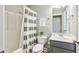 Well-lit bathroom has a shower-tub, a toilet, and a vanity with a mirror at 3480 Indian Shoals Rd, Dacula, GA 30019
