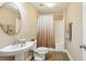 Neutral bathroom featuring a pedestal sink, round mirror, and shower/tub combo with a decorative shower curtain at 3480 Indian Shoals Rd, Dacula, GA 30019