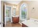 Bright bathroom featuring tile flooring, dual vanities, and a large arched window at 3480 Indian Shoals Rd, Dacula, GA 30019