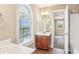 Bright bathroom featuring tile flooring, dual vanities, and a large arched window at 3480 Indian Shoals Rd, Dacula, GA 30019