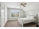 Bright bedroom with a ceiling fan, a large window, and a crisp white bed frame at 3480 Indian Shoals Rd, Dacula, GA 30019