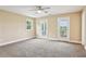 Spacious bedroom with neutral carpet, ceiling fan, and two sets of doors to the outside at 3480 Indian Shoals Rd, Dacula, GA 30019