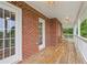 Covered deck features brick accents, white railings, ceiling fans, and wooded views at 3480 Indian Shoals Rd, Dacula, GA 30019
