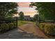 Long driveway leading to a stately home with a covered porch, as seen through a gated entrance at 3480 Indian Shoals Rd, Dacula, GA 30019