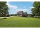 Stately home with a charming white balcony overlooking lush green lawn, framed by mature trees and blue skies at 3480 Indian Shoals Rd, Dacula, GA 30019
