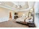 A sun-lit bedroom featuring a tray ceiling, bedroom set, and windows letting in natural light at 3480 Indian Shoals Rd, Dacula, GA 30019